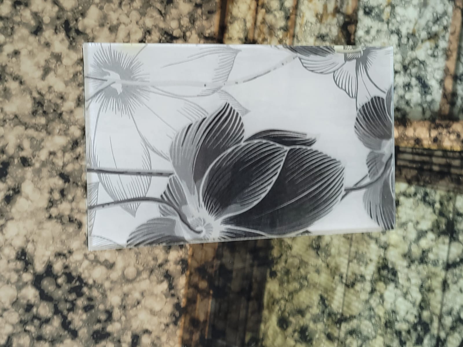 Monochrome floral glass — Large black flowers against a pale background.
