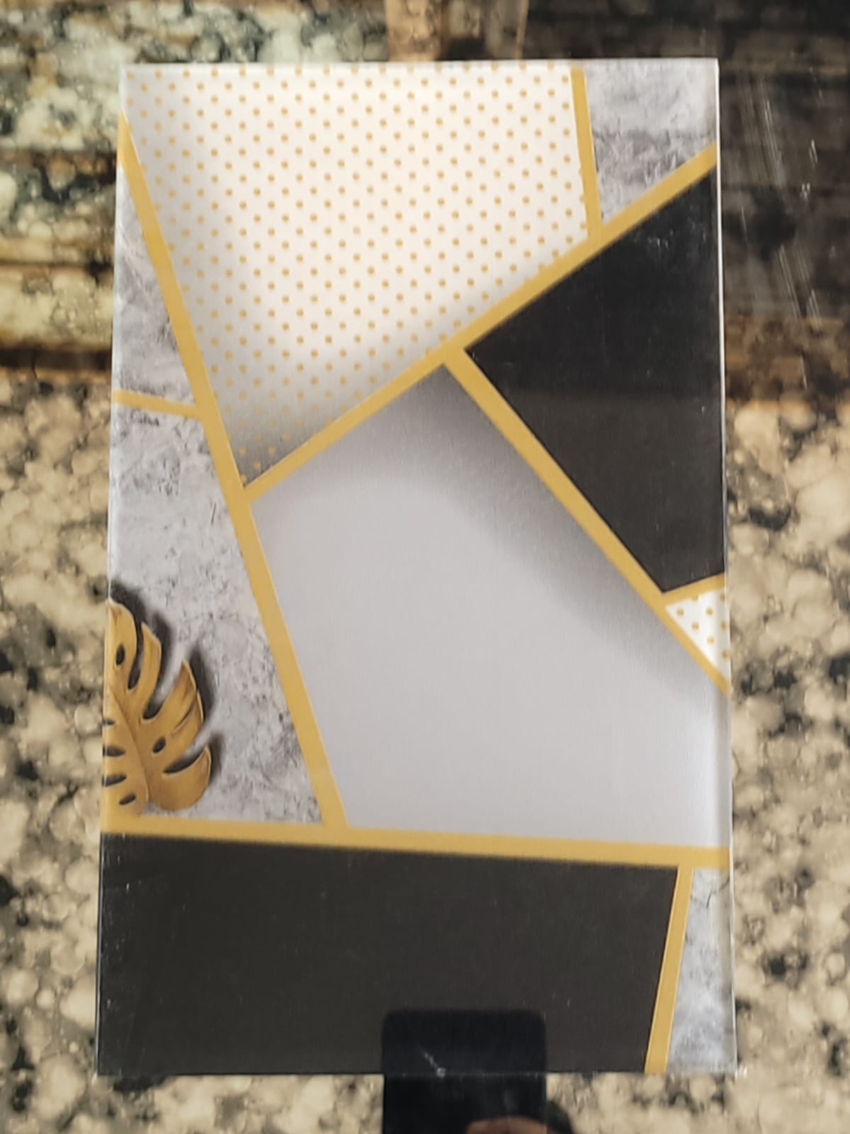 Angular colour-block glass — Black, white and grey shapes divided by gold lines.