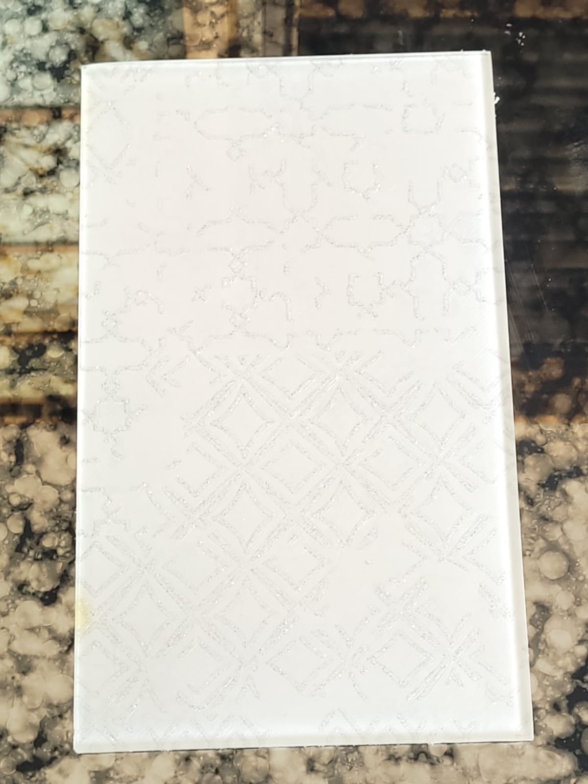 White patterned glass — Subtle white-on-white geometric patterning.